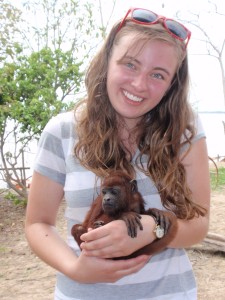 Becky Friesen holding a baby howler monkey during her research trip in Peru.