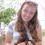 Becky Friesen holding a baby howler monkey during her research trip in Peru.